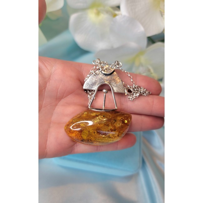 Natural large Beauty Golden Polish Amber .925 Sterling Silver handmade necklace - Close-up of large golden amber pendant with silver details on hand.