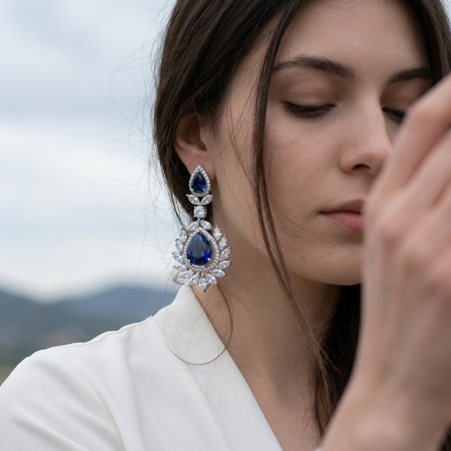 Vintage style - Giovanna - Authentic pear cut 8.9 carat Sapphire .925 Sterling Silver handcrafted earrings - Close-up of vintage sapphire earrings worn by a woman.