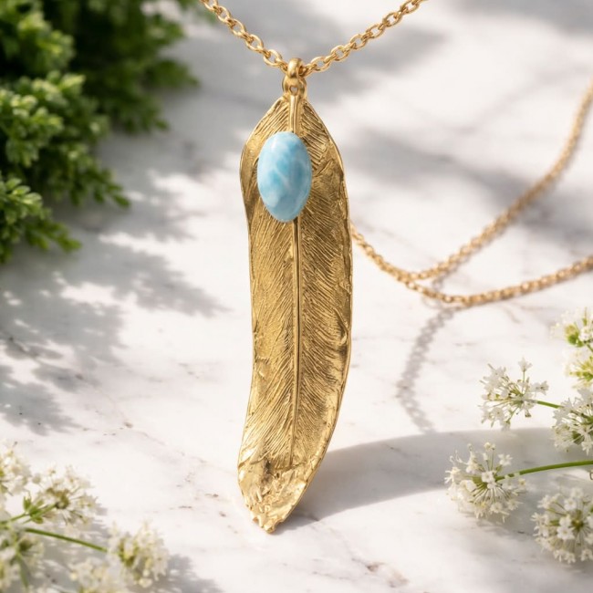 Natural Leaf Larimar 14K Gold over .925 Sterling Silver handmade - Gold leaf pendant with Larimar stone, hanging on a marble surface.