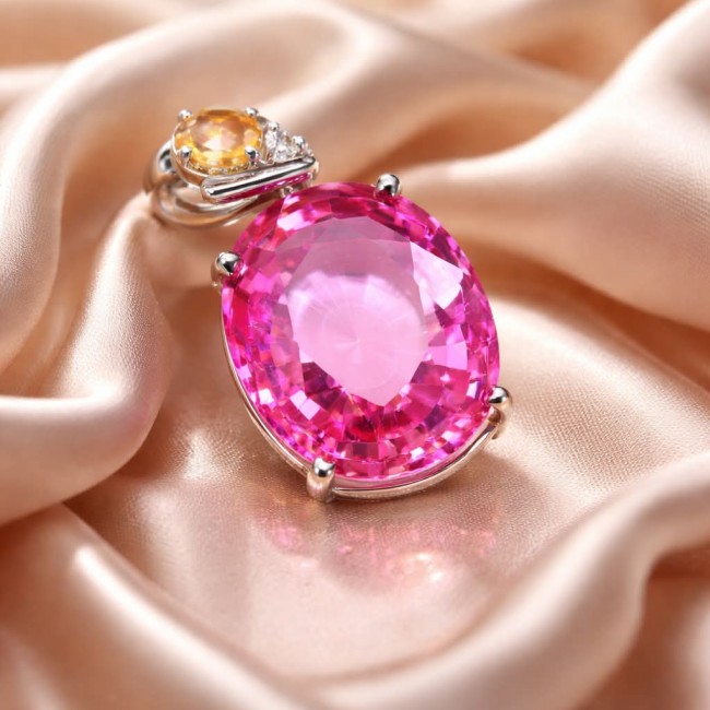 Incredible oval cut 27.8 carat Pink Sapphire .925 Sterling Silver handcrafted pendant - Close-up of 27.8 carat pink sapphire pendant on satin background.