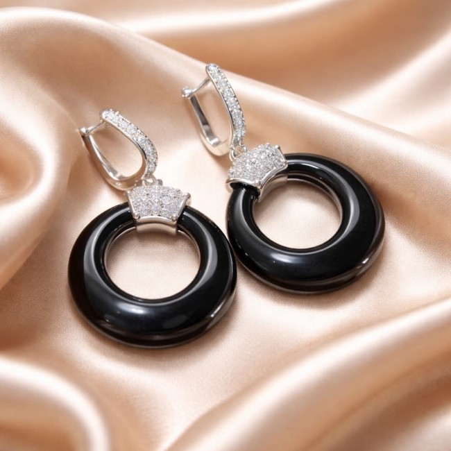 Outstanding authentic Onyx .925 Sterling Silver Earrings - Onyx and silver earrings on satin, top angle view.
