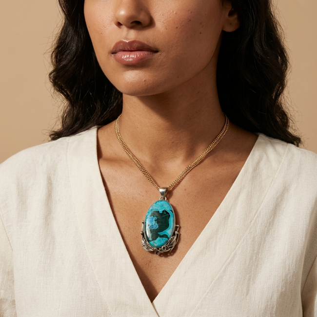 Colors of the Earth Authentic Chrysocolla .925 Sterling Silver handcrafted Large Pendant - Chrysocolla pendant on model, front view, cream blouse background.