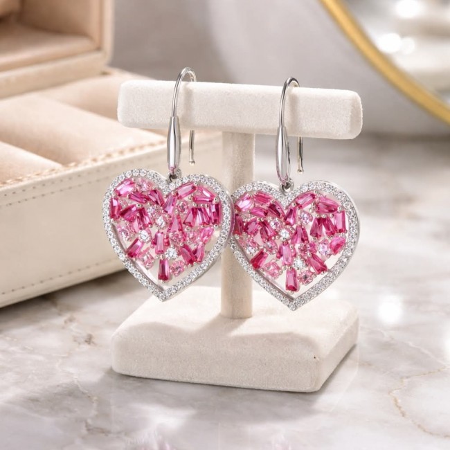 Precious Hearts - authentic 12.5 carat Mozambique Ruby .925 Sterling Silver dipped in rhodium handcrafted Statement Earrings - Heart-shaped earrings with pink stones on a display stand.