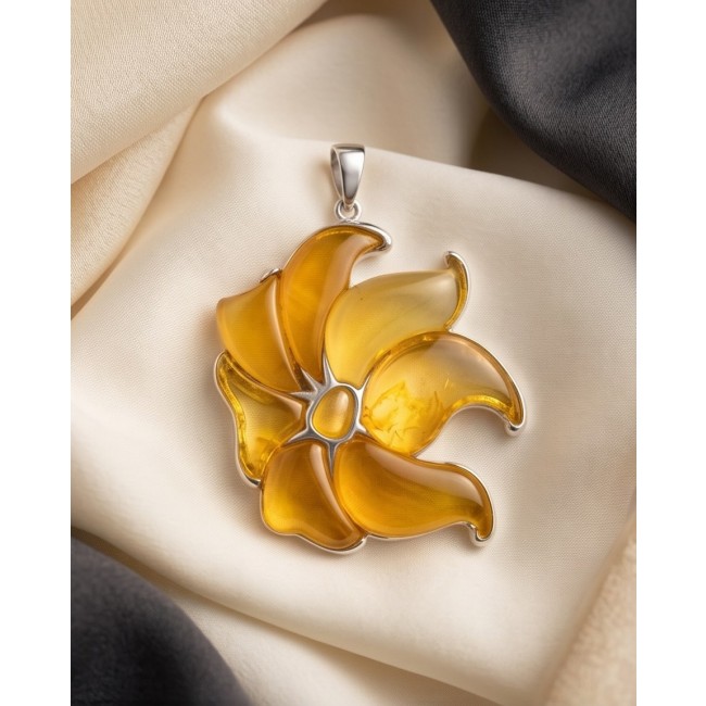 Golden Wild Lotus Natural Butterscotch Baltic Polish Amber .925 Sterling Silver dipped in rhodium handcrafted Pendant - Golden lotus amber pendant on fabric, top view.