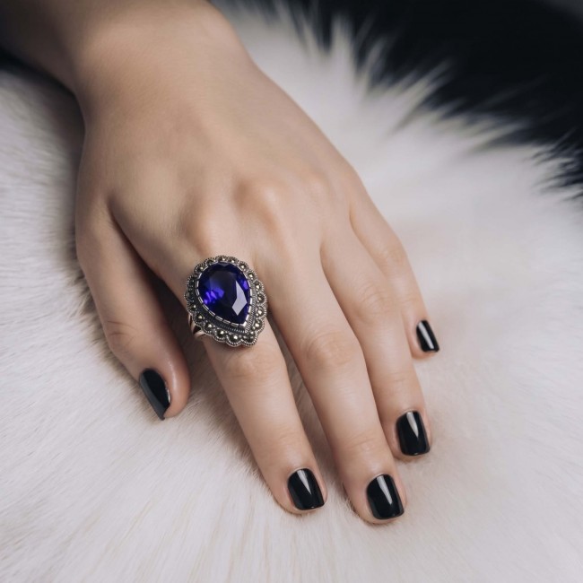 Julietta 12.8 carat London Blue Topaz Marcasite .925 Sterling Silver handmade Statement Ring size 6 - Julietta blue topaz ring on hand, black nails, white fur background.