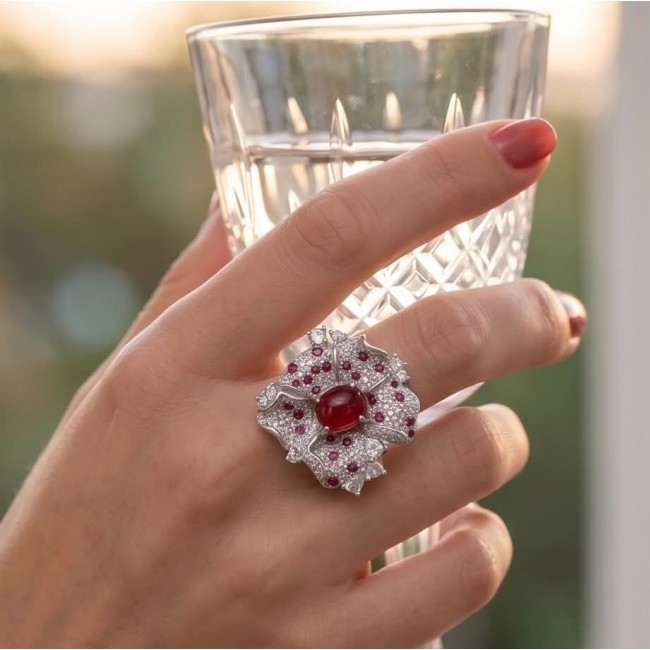 Carmen Natural 6.4 carat Ruby .925 Sterling Silver dipped in rhodium handmade Large Statement Ring size 9 - Hand wearing Carmen Ruby ring holding a crystal glass.