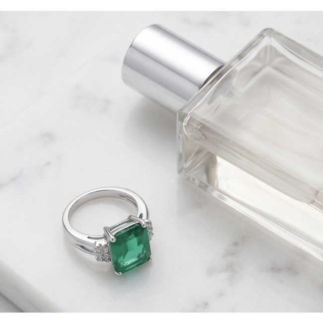 Precious 11.5 carat emerald cut EMERALD .925 Sterling Silver handcrafted ring; s. 8 - Emerald ring side view with perfume bottle on marble surface