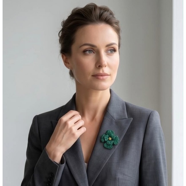 Retro Style - Precious Rose Genuine 22.5 carat Colombian Emerald black rhodium over .925 Sterling Silver handmade Pendant - Brooch - Woman wearing a gray suit with green floral brooch on lapel.