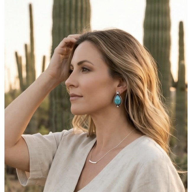 Great authentic Morenci Turquoise .925 Sterling Silver handcrafted Earrings - Side view of turquoise earrings worn outdoors near cacti.