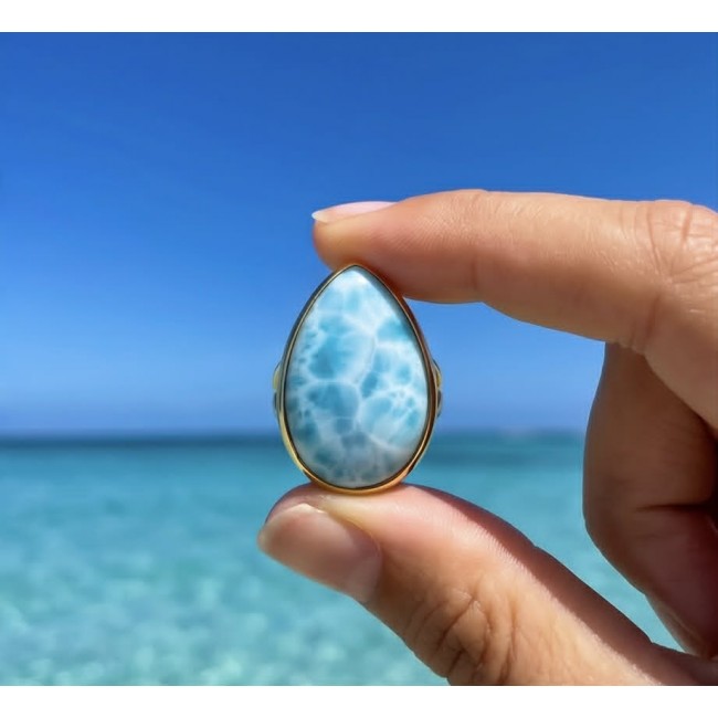 Blue Perfection 22.9 carat natural Larimar .925 Sterling Silver dipped in 18K Gold handmade Large ring size 7 - Larimar stone close-up held against a clear blue ocean background