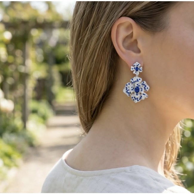 Oceania - 9.5 carat Sapphire .925 Sterling Silver dipped in Rhodium handmade Statement earrings - Side view of Oceania sapphire earrings worn on ear in garden setting.