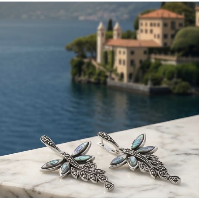 Blue Butterfly Genuine Rainbow Abalone .925 Sterling Silver handcrafted Statement Earrings - Dragonfly earrings on marble ledge with lake view in background.
