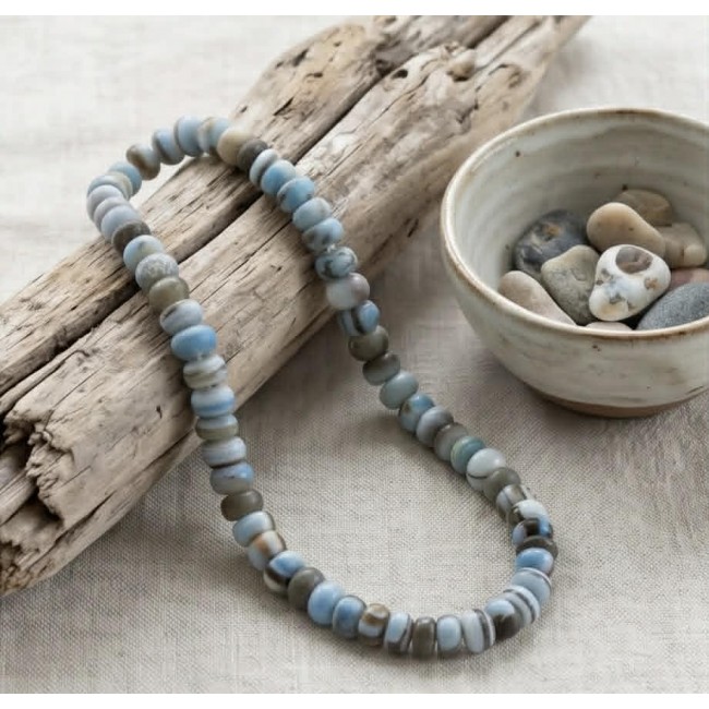 Rare and Spectacular 225.9 carat authentic Andean (Peruvian) Blue Opal .925 Sterling Silver Handcrafted necklace - Beaded necklace on driftwood, with a bowl of stones nearby.