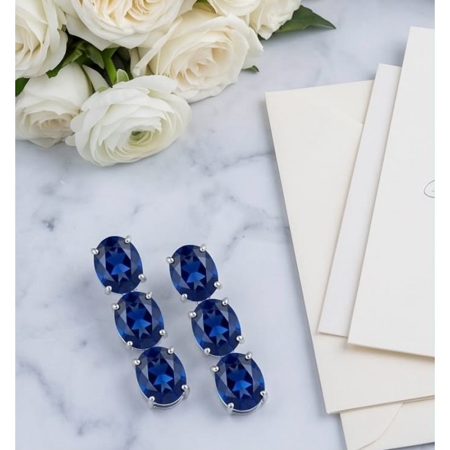 Deep Ocean 22.5 carat London Blue Topaz .925 Sterling Silver handmade Statement earrings - Blue Topaz earrings on marble with roses and envelopes, top view.