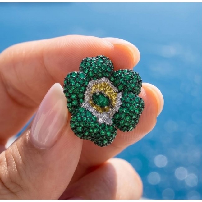 Born to Glam authentic 20.2 carat Colombian Emerald .925 Sterling Silver handcrafted earrings - Close-up of emerald flower jewelry held between fingers.