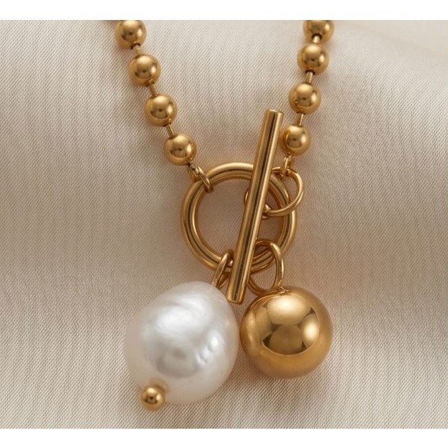 Top quality Natural Mother of pearl 10K Gold over .925 Sterling Silver handcrafted necklace - Close-up of gold and pearl pendant with clasp detail on fabric background.