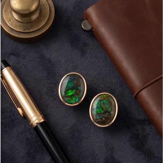 Sublime Aura Canadian Fire Ammolite 14K Gold over .925 Sterling Silver handmade earrings - Close-up of Ammolite cufflinks in gold setting on a dark background.
