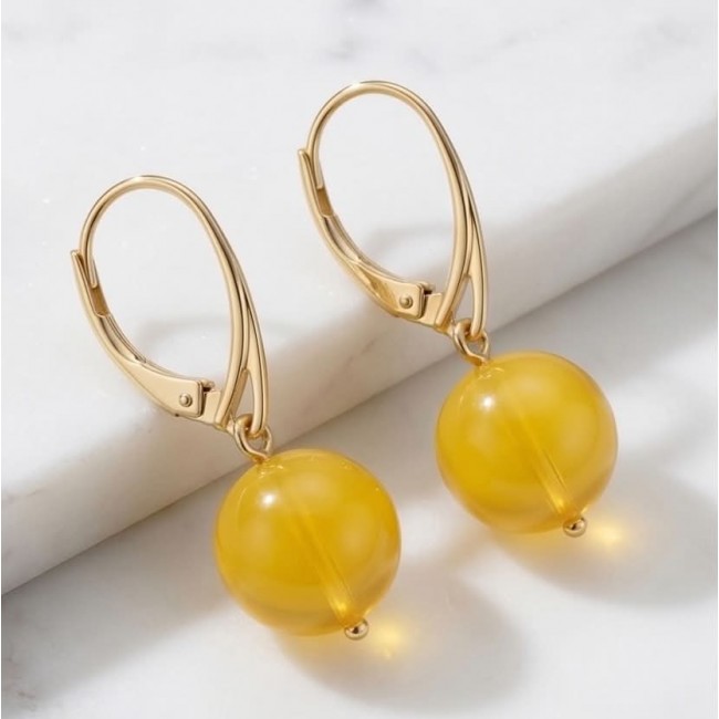 Very Special product - Wonderful Butterscotch Baltic Amber .925 Sterling Silver DIPPED IN 14k Gold entirely handcrafted earrings - Close-up of gold earrings with butterscotch Baltic amber spheres.