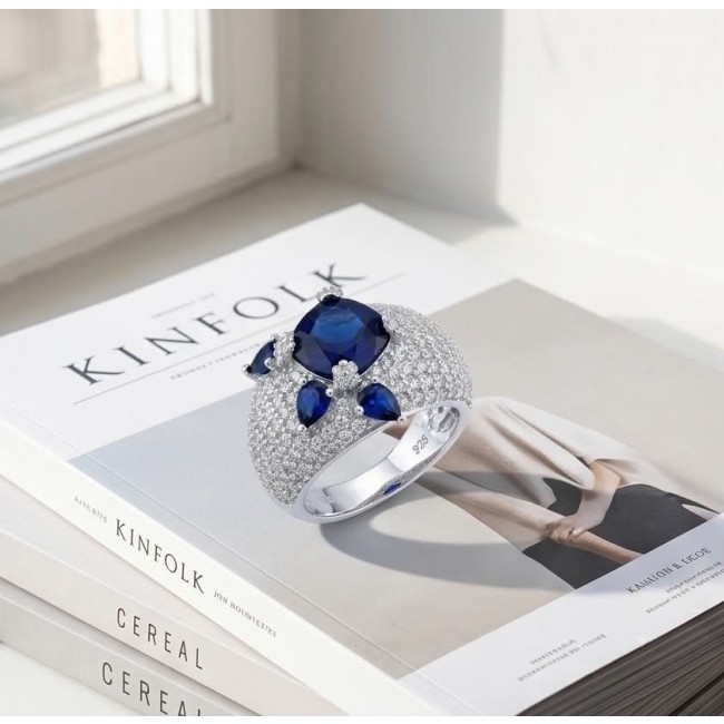 Blue Extravaganza 12.2 carat natural Sapphire .925 Sterling Silver Perfectly handcrafted Ring s. 7 - Blue sapphire ring on stacked books, top view, featuring main stone.