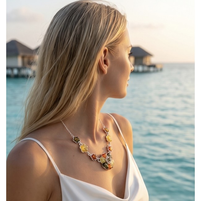 Floral design - natural multicolor Baltic Amber .925 Sterling Silver handcrafted necklace - Side view of floral Baltic Amber necklace worn by a woman at the beach.