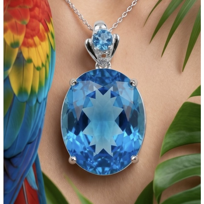 Paradise Found - Vintage style 26.8 carat Swiss Blue Topaz .925 Sterling Silver DIPPED IN RHODIUM handmade Pendant - Close-up of Swiss Blue Topaz pendant with parrot feathers in background