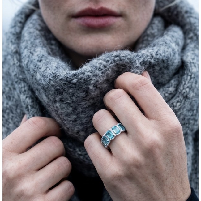 Angel's Wish 22.8 carat Aquamarine .925 Sterling Silver handcrafted infinity ring size 8 - Close-up of aquamarine ring on hand against a gray scarf background.