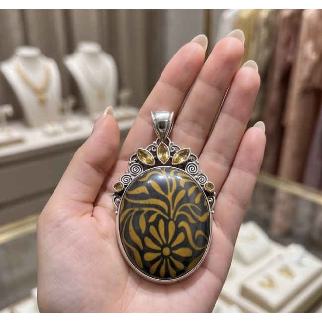 Exotic Beauty Silver Hematite Citrine .925 Sterling Silver handmade Pendant - Pendant close-up held in hand, featuring yellow floral design and citrine stones.