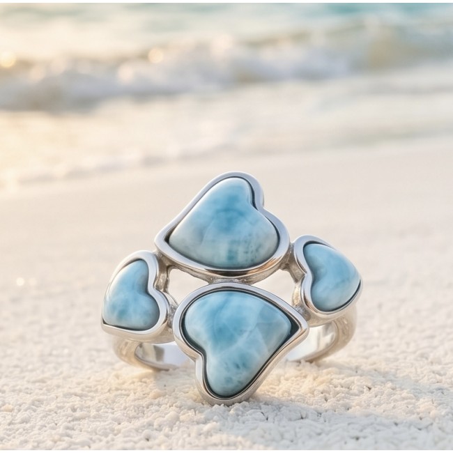 12.9 carat Blue Hearts natural Larimar .925 Sterling Silver handmade ring size 8 1/4 - Close-up of blue heart Larimar ring in silver on sand with sea in background.