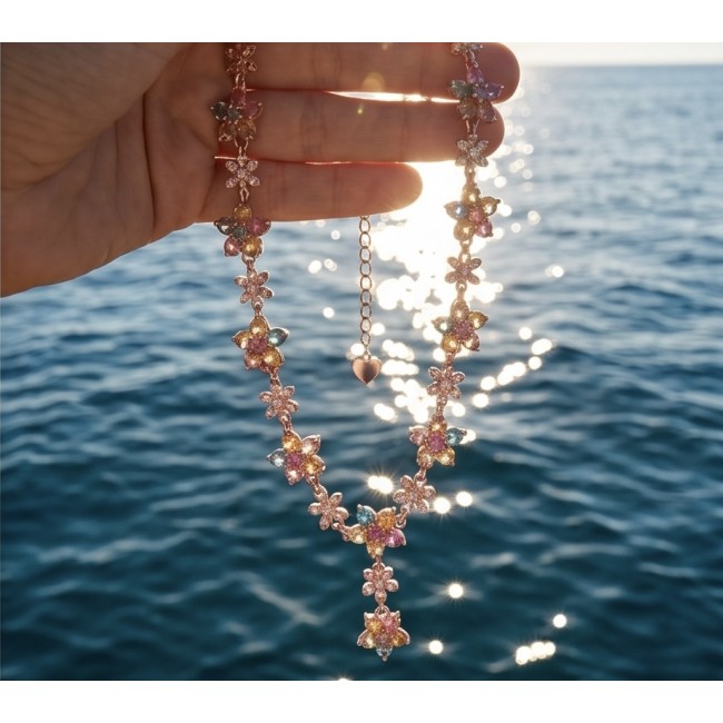 Luxurious - 10.5 carat yellow multicolor Sapphire .925 Sterling Silver dipped in 18K Rose Gold handcrafted Necklace - Hand holding multicolor sapphire necklace over ocean background.
