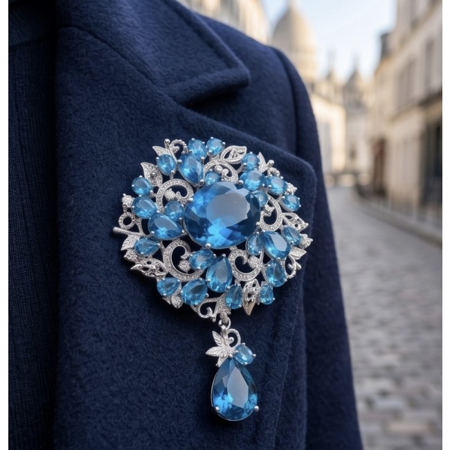 An exuberantly Large 70.2 grams Vintage style Swiss Blue Topaz .925 Sterling Silver DIPPED IN RHODIUM handmade LARGE Pendant - Brooch - Close-up of large blue gemstone brooch on a dark coat