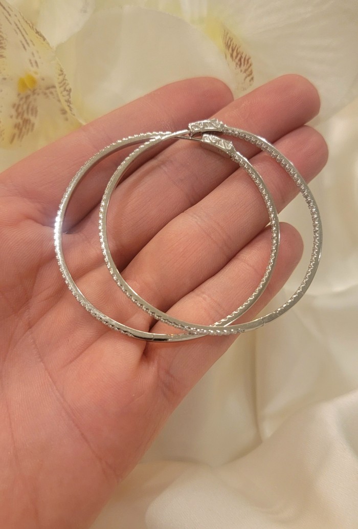 INSIDE - OUT Huge 2 inches long White Sapphire .925 Sterling Silver handmade Hoop Earrings - Hoop earrings in hand, showcasing clasp detail and shimmering sapphires.