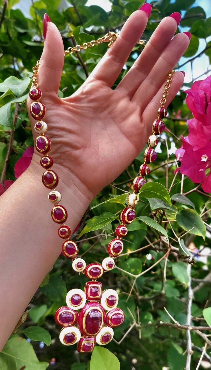 Outstanding - Red Rose - Authentic Kashmir 155.8 carat Ruby Enamel 18K Gold over .925 Sterling Silver handcrafted Station necklace - Hand holding Authentic Kashmir Ruby necklace among green leaves.