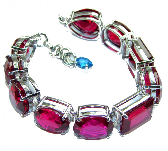 Passion - Magnificent 247.4 carat Red Ruby .925 Sterling Silver handcrafted Heavy Bracelet - Bracelet with red rubies and blue accent, front angle view.