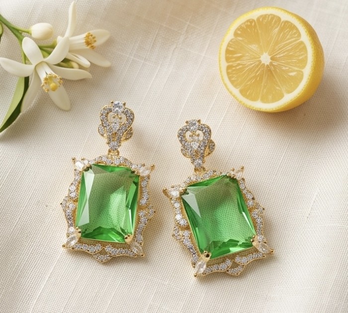 Green Cascade - 12.5 carat Green Topaz 14K Gold over .925 Sterling Silver handmade Statement earrings - Green Cascade earrings front view with flowers and lemon slice.