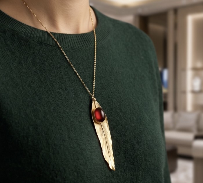 Stylish REAL Leaf dipped in gold Boulder Opal .925 Sterling Silver Pendant - Gold-dipped leaf necklace with red opal, worn on a green sweater.