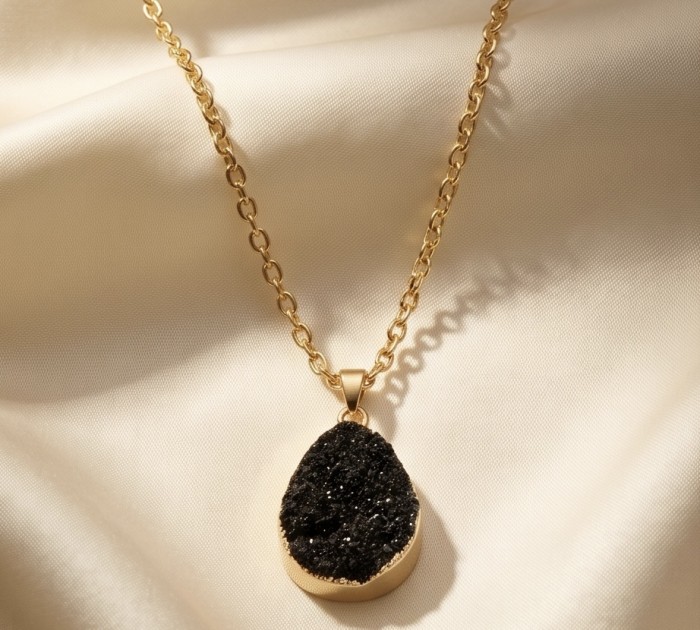 Boho Style Genuine Black Druzy .925 Sterling Silver handmade necklace - Black druzy necklace close-up on gold chain with fabric background.