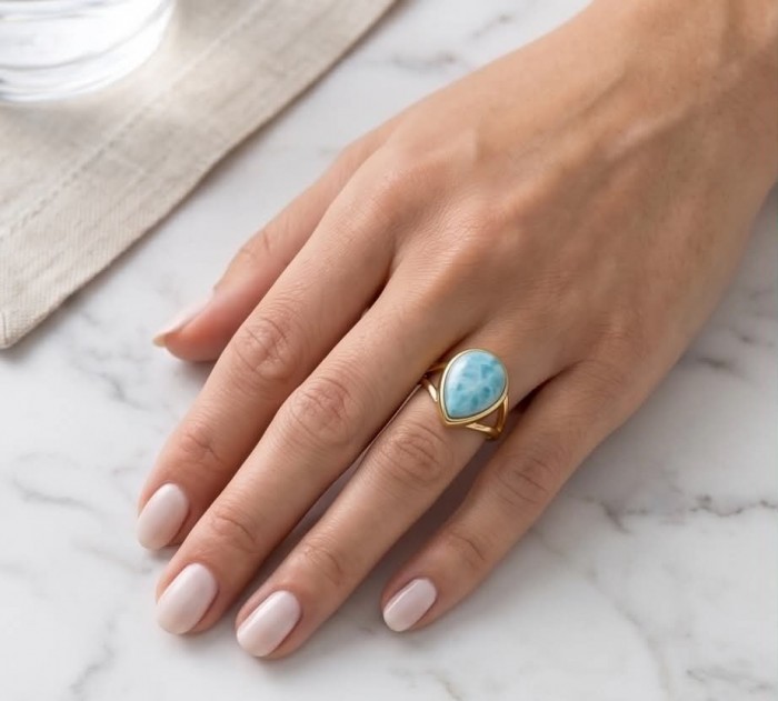 Treasure of Dominican Republic 12.5 carat genuine Larimar .925 Sterling Silver dipped in 22K Gold over Handcrafted Ring size 6 - Larimar ring worn on hand, showing stone and gold band on marble surface.