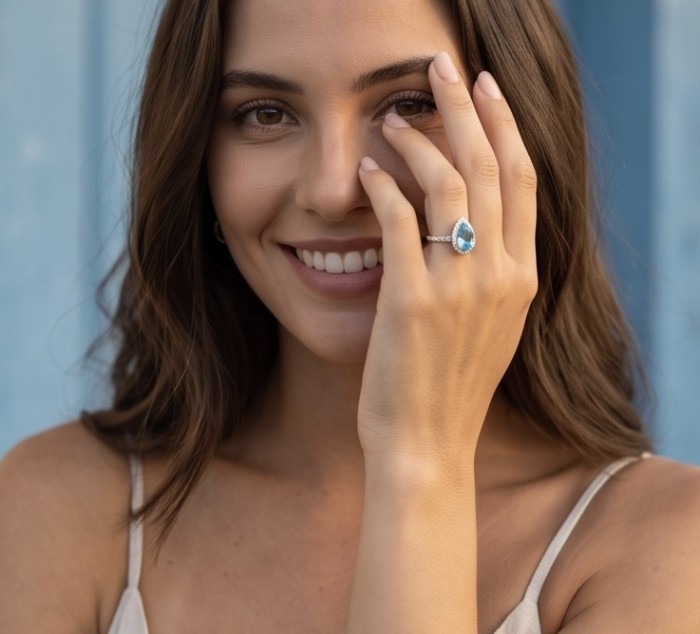 Ocean's Drop 6.8 carat genuine Swiss Blue Topaz .925 Sterling Silver handcrafted ring size 8 - Woman wearing Ocean's Drop Swiss Blue Topaz ring on hand close-up.