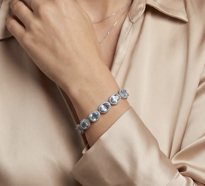 Tiffany - Magnificent 41.5 carat Swiss Blue Topaz .925 Sterling Silver handcrafted Bracelet - Blue Topaz bracelet worn on wrist, showcasing stones against a satin blouse.