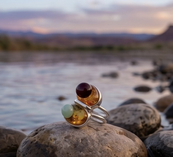 Perfect Harmony - Unique design Authentic Baltic Amber .925 Sterling Silver handcrafted ring; s. 7 adjustable - Close-up of Perfect Harmony Baltic Amber ring on rocks by a river