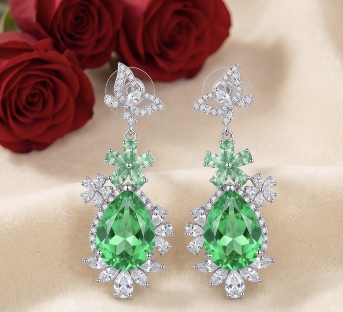 Green Cascade - 18.5 carat Green Topaz rhodium over .925 Sterling Silver handmade Statement earrings - Elegant drop earrings with green topaz, front view, red roses backdrop