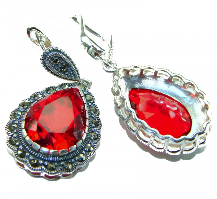 Crimson Fire Authentic 18.9 carat Garnet .925 Sterling Silver brilliantly handcrafted earrings - Close-up of Crimson Fire garnet earrings with silver detailing.