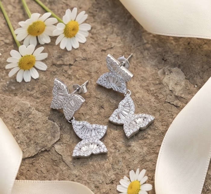 Four Butterflies natural 7.5 carat White Topaz .925 Sterling Silver handmade Statement Earrings - Butterfly earrings with white topaz on stone background, side view.