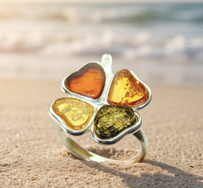 Flower Authentic Baltic Amber .925 Sterling Silver dipped in rhodium handcrafted ring; s. 7 adjustable - Clover-shaped amber ring on sand, ocean blurred in background