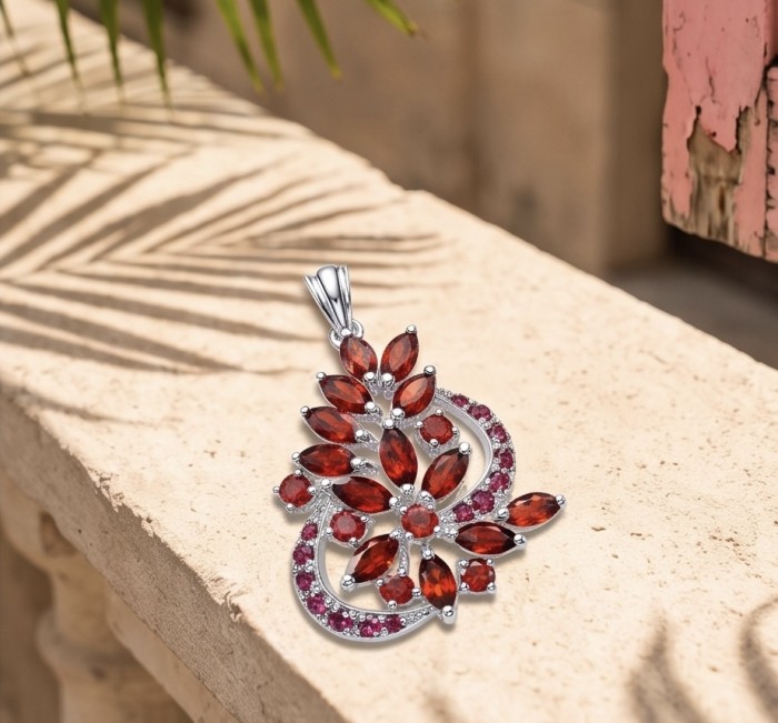 Marvelous Natural 20.8 carat Mozambique Garnet .925 Sterling Silver Handcrafted pendant - Elegant garnet pendant on stone surface, top view, silver setting.