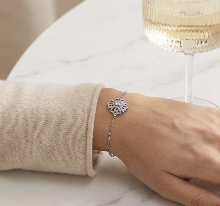 Isabella authentic 10.2 carat White Topaz .925 Sterling Silver handcrafted Statement Bracelet - Isabella bracelet worn on wrist, close-up with wine glass in background.