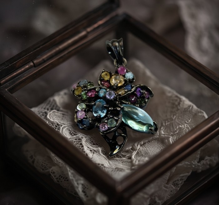 Colors of the Earth Precious 14.5 carat Multigem .925 Sterling Silver dipped in black rhodium Pendant - Multigem pendant in a glass box, top view on lace fabric.