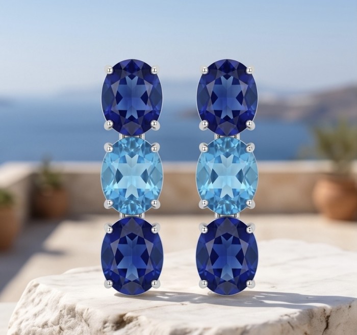 Oceania - 22.5 carat London Blue Topaz .925 Sterling Silver handmade Statement earrings - Front view of Oceania earrings with blue topaz on white stone background