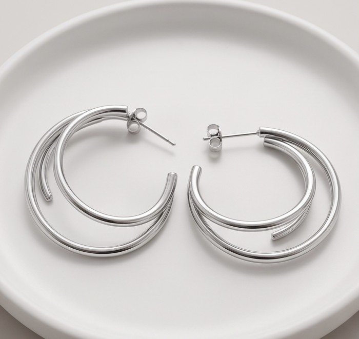 Allure Natural .925 Sterling Silver handcrafted hoop earrings - Silver hoop earrings on a plate, top view, showcasing design detail.