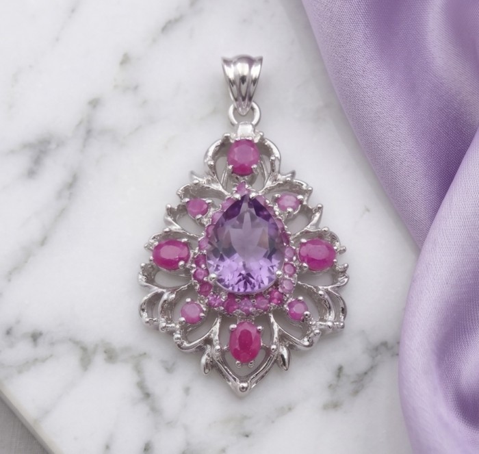 Francesca Genuine 18.5 carat Amethyst Kashmir Ruby rhodium over .925 Sterling Silver handmade Pendant - Ornate pendant with amethyst and rubies on marble and lilac fabric.